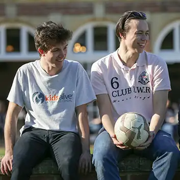 Two young people sitting on a wall