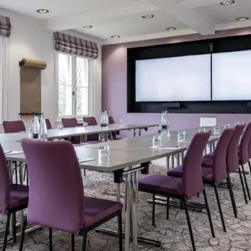 A meeting room with tables and chairs