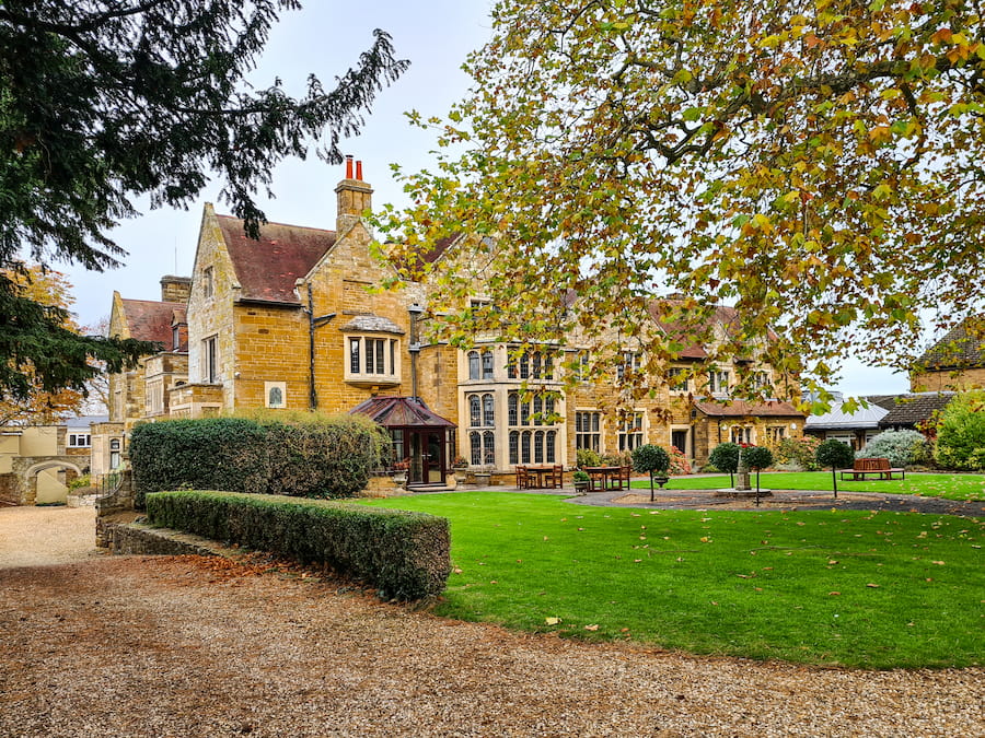 Highgate House with the big tree starting to show autumn colours with reds, orange and yellow leaves.