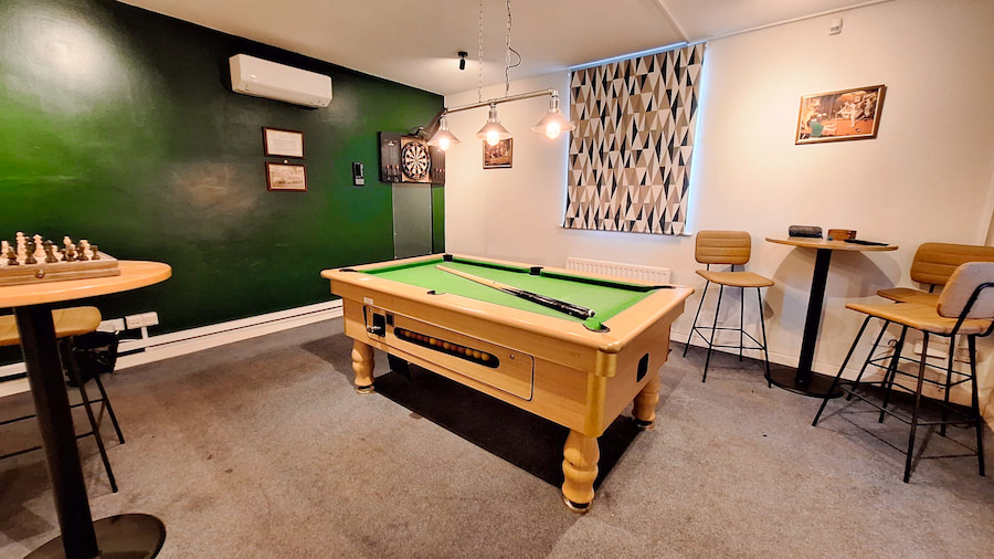 The games room with a pool table and darts. 