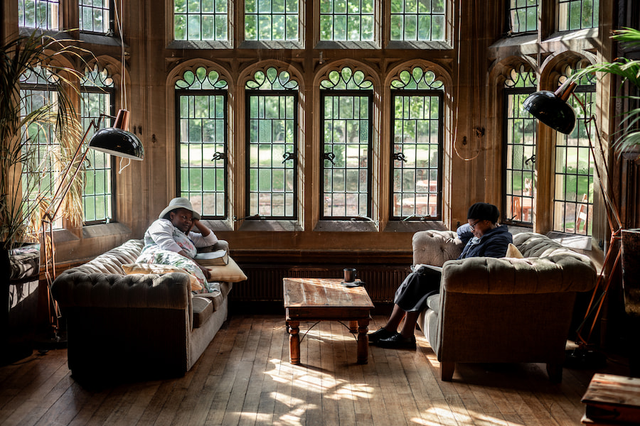 Guests relaxing on sofas in the Baronial Hall at Highgate House.