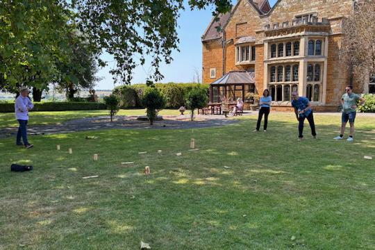 People playing a game on the lawn at Highgate House in the sun.
