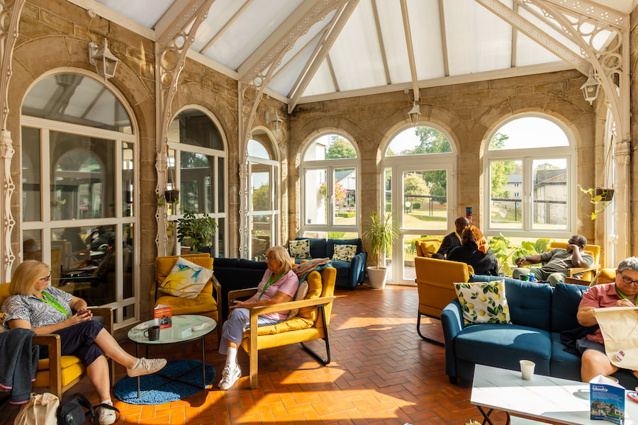 The Vinery today with guests sitting around in conversation while the sun streams through.