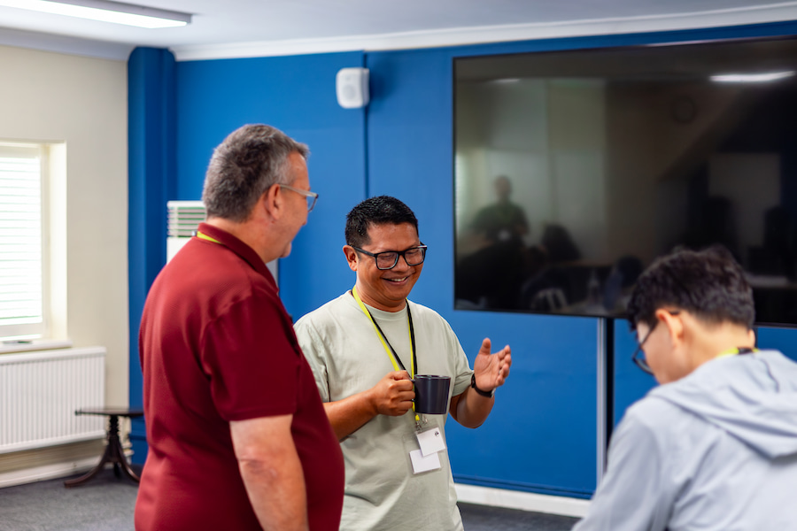 A Board member laughing while talking to another Board member at Highgate House.
