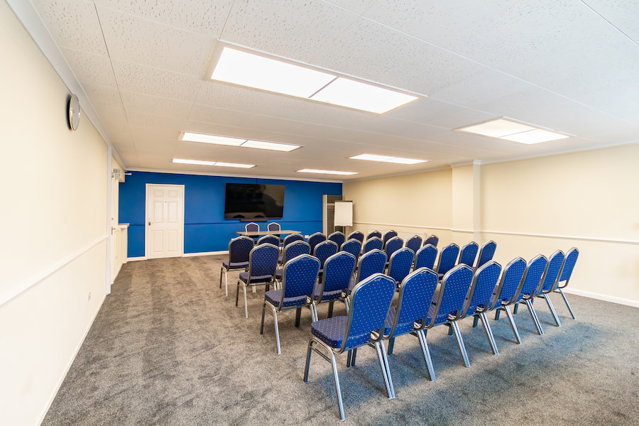 Ismay with brand new carpet and a royal blue accent wall with a big tv.