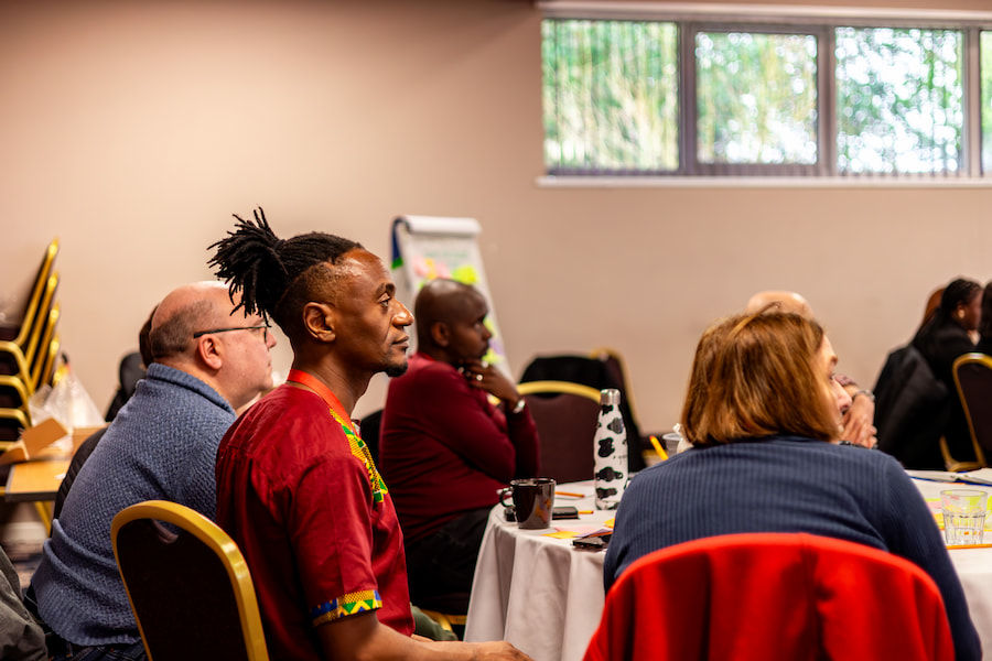 A man in a conference looking to the front, listening to the speaker.