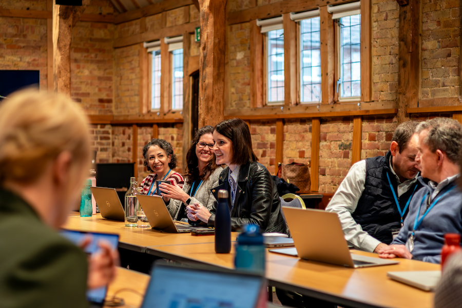 Janie Oliver laughing as she's talking to the board of trusties in the Chapel Barn at High Leigh during their conference.