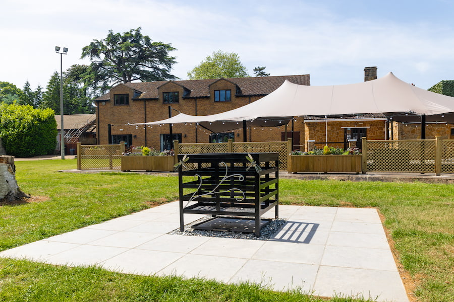 The firepit with the stretch tent in the background in a sunny day.