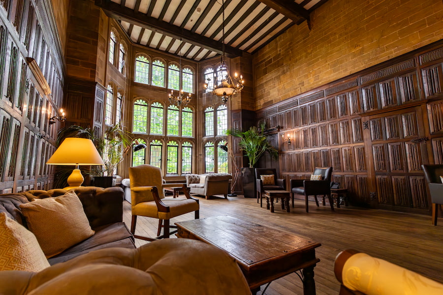 The Baronial Hall from the angle of one of the sofas showing the magnificent window and cosy lighting.