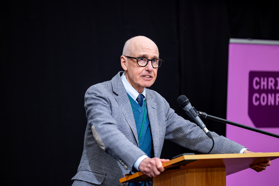 Professor Glynn Harrison speaking at the podium. 