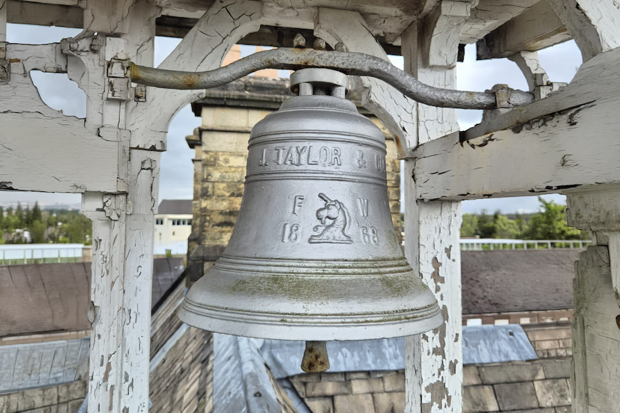 The Hayes' bell on top of the roof of the main house with countryside visible in the background.