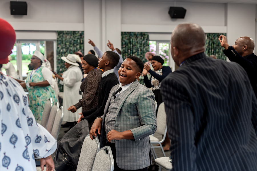 A boy worshipping in the Aspen Hall at Highgate House with his church.