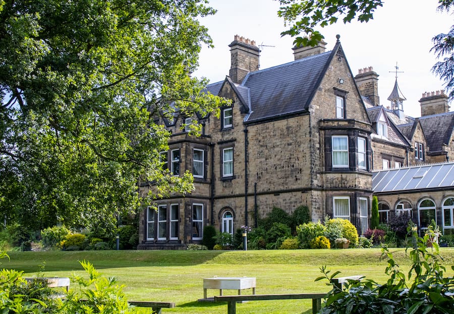 The Hayes main house building today with firepits and the same large tree.