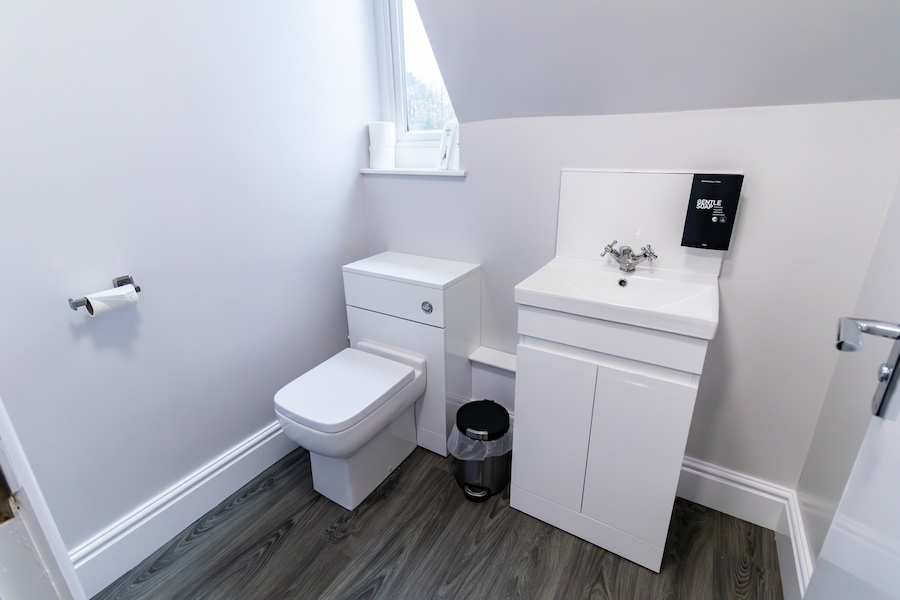 The toilet with brand new flooring and lighting creating a modern look.