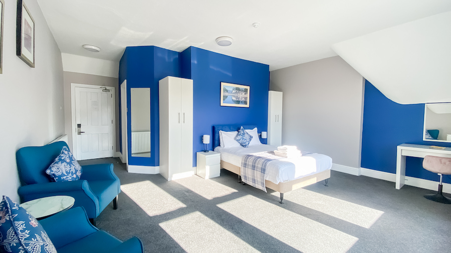 Room 65 with brightly colour blue walls and tasteful matching furniture.