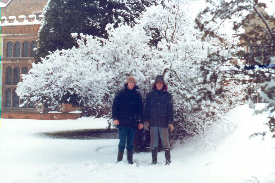 An image of 2 maintenance staff standing in the snow next to a large mound (the air raid shelter).