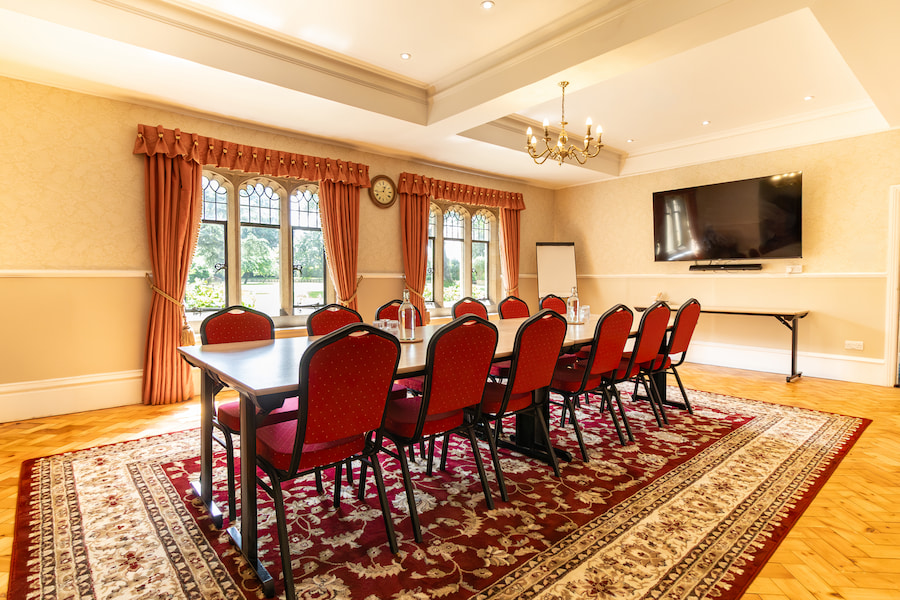 Pine set out in boardroom style showing the tv on the wall.