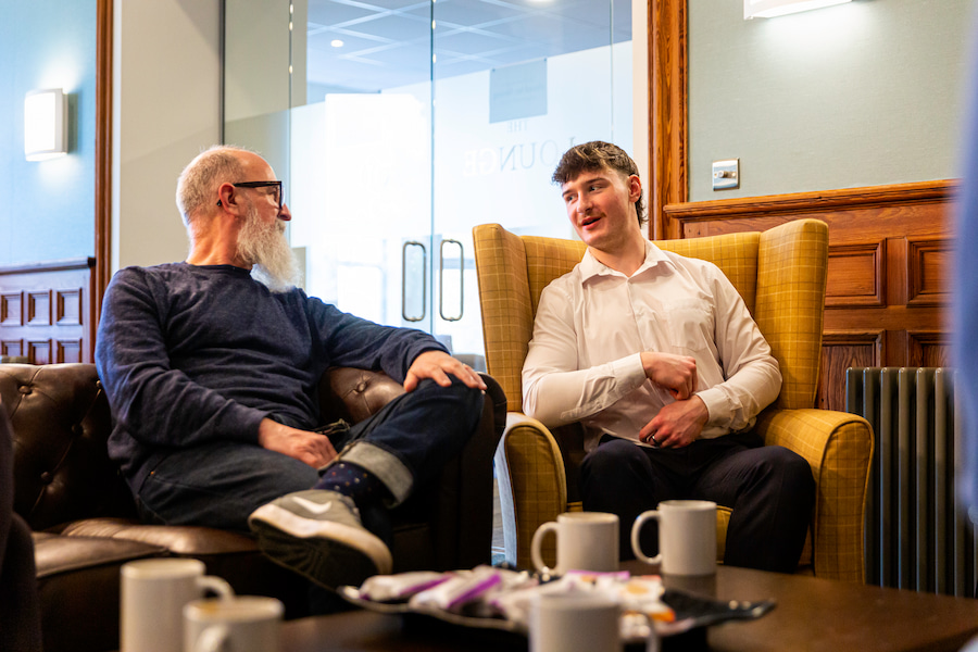 2 men sitting together chatting and relaxing.