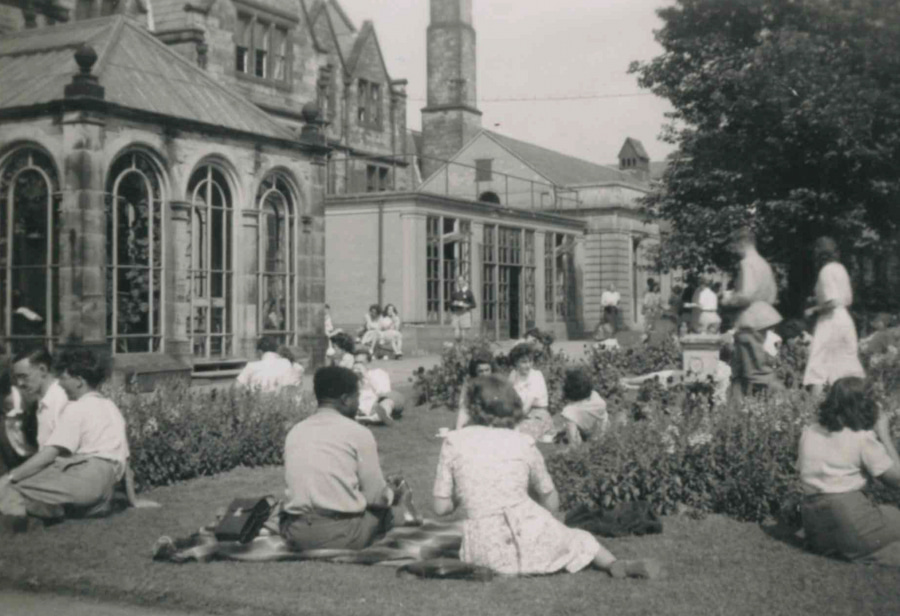 The exterior of the Vinery in black and white with people sitting out on the lawn enjoying fellowship.