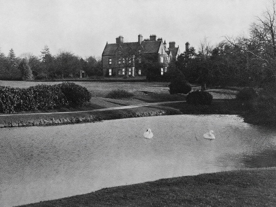 An old photograph showing the lower lake at The Hayes with the building visible in the distance.