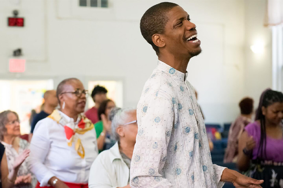 A man worshipping with a big smile on his face