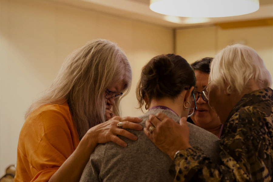 A group of women praying together.