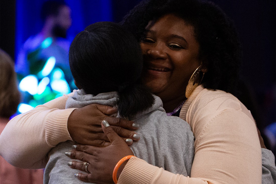 2 women hug and smile